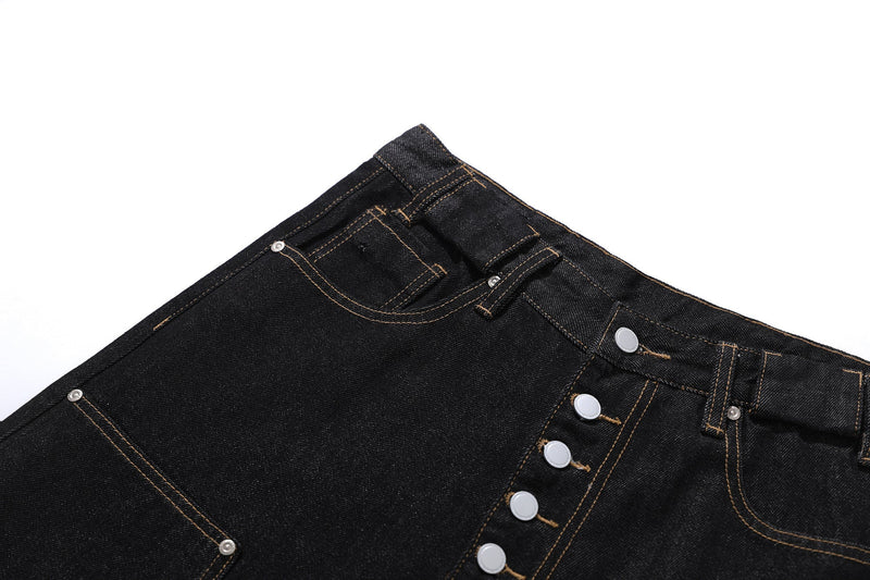 Close-up of black denim waistband and front pocket details with visible stitching