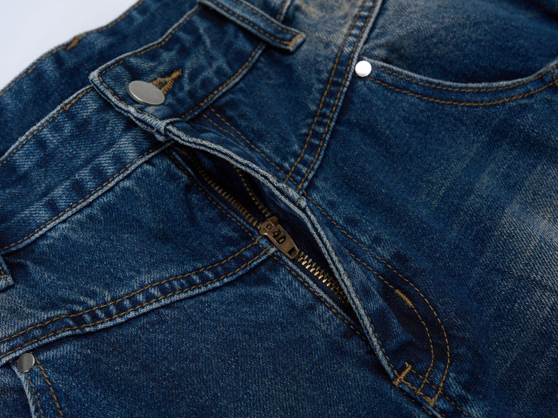 Close-up of the front fly on blue jeans showing zipper and top button