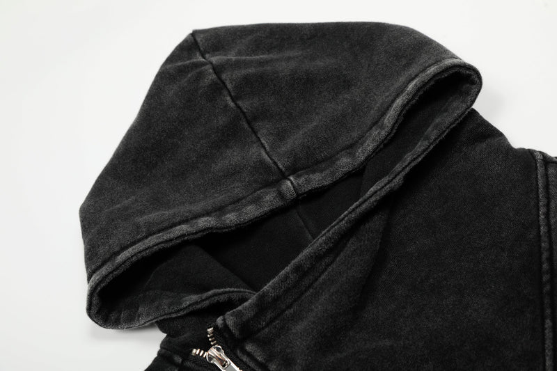 Close-up of black hooded jacket collar and asymmetrical zipper at the neckline