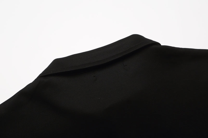 Black embroidered gothic polo shirt in textured cotton fabric with a raised collar and minimalist detailing