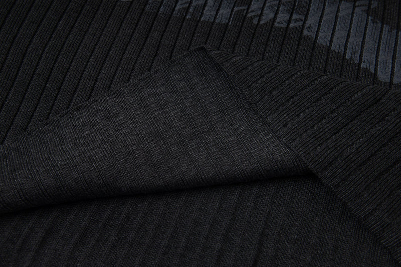 Close-up of black ribbed knit fabric laid folded with Number 12 print detail
