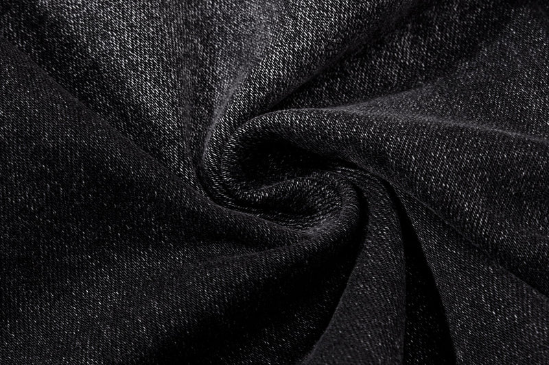 Close-up of black washed denim fabric texture with twisted folds