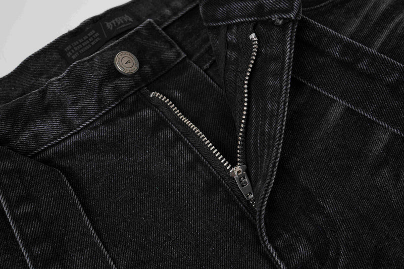 Close-up of black denim shorts front zipper and waistband button