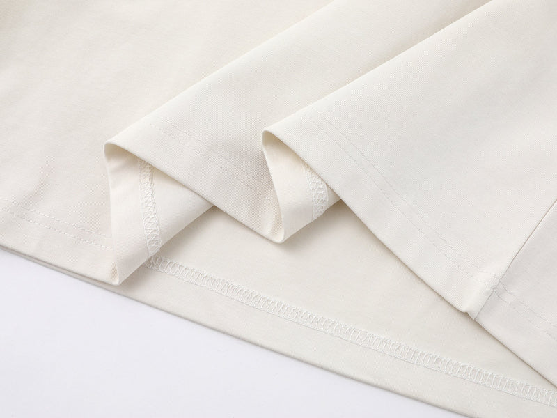 Close-up of cream fabric hem and stitching on the layered long tee