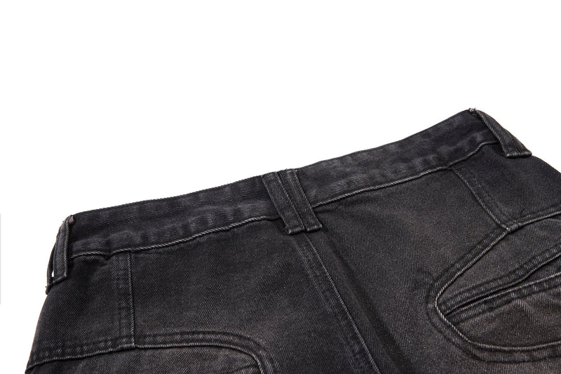 Close-up of black denim back waist with belt loops and pocket seam details