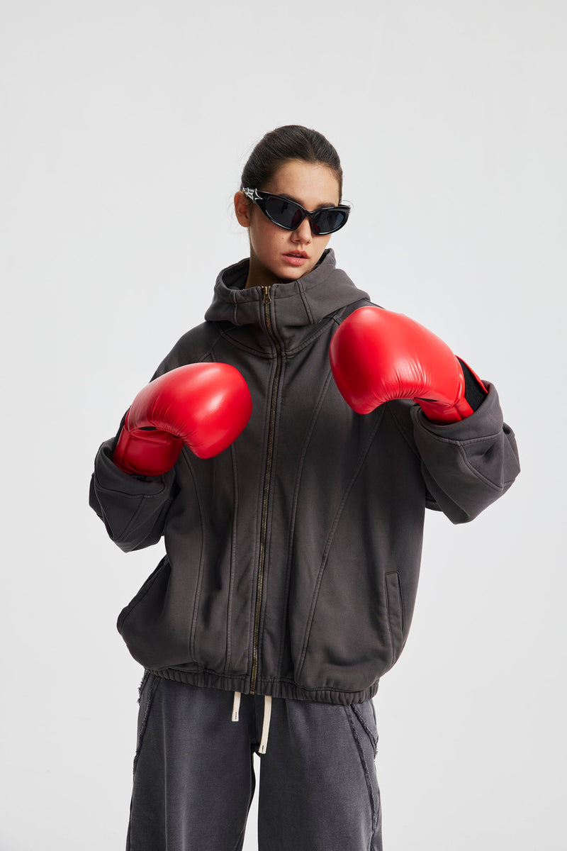 Model wearing charcoal gray hoodie with red boxing gloves, front view