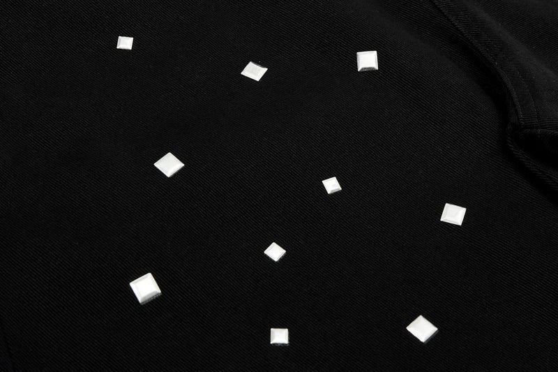 Close-up of black denim with scattered silver square studs