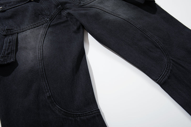 Close-up of black cargo jeans leg with curved seam and side pocket edge