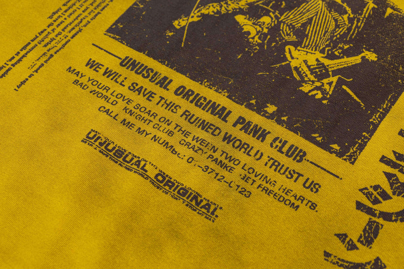 Mustard yellow washed tee with distressed punk-style black graphic print and bold retro text details