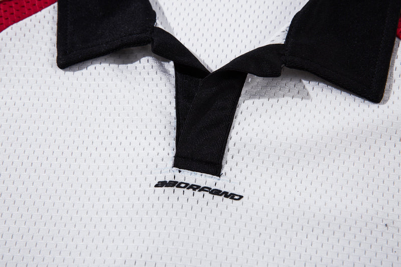 Close-up of a white mesh polo jersey with black patchwork collar detail and Seakoff branding at the neckline