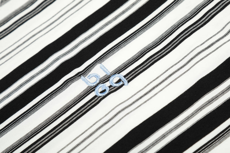 Close-up of black and white striped fabric with small light blue embroidered logo
