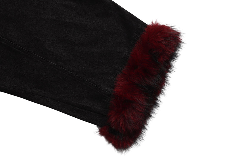 Close-up of black denim hem with red faux fur cuff trim