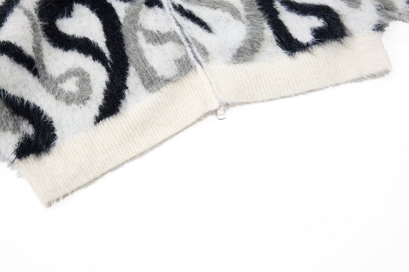 Close-up of cream ribbed hem on black and white faux-fur zip hoodie