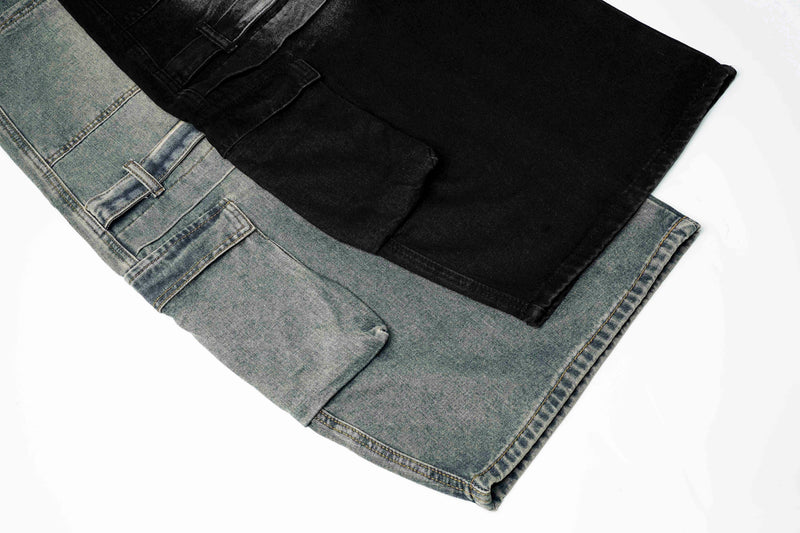 Close-up of stacked blue and black jeans hems with cargo pocket flaps