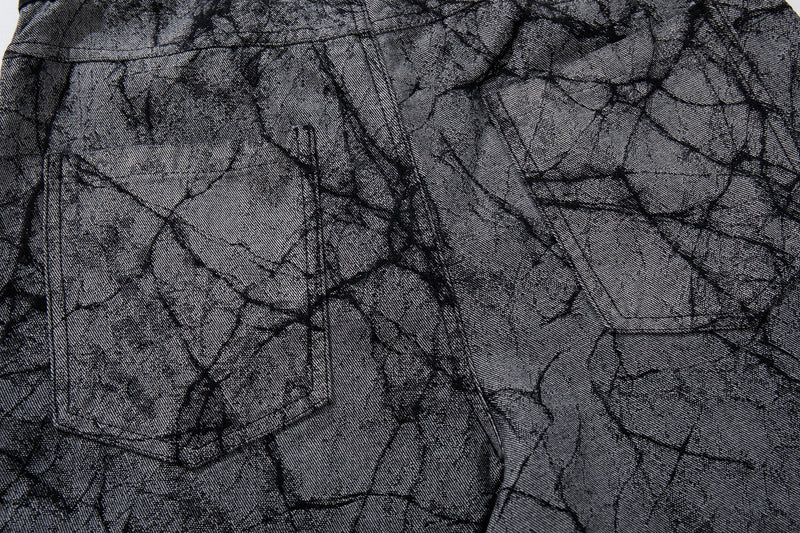 Close-up of front pocket area on gray cracked-texture denim pants