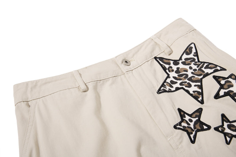 Close-up of beige waistband with belt loops and leopard star patch detail