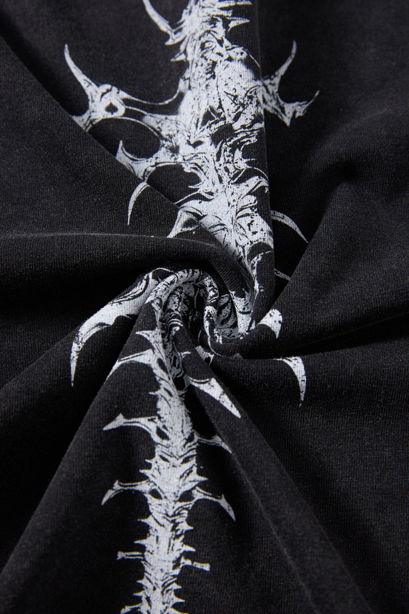 Black washed T-shirt with a white spine graphic print, shown in a close-up of the folded fabric texture