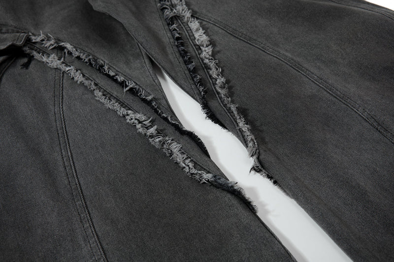 Close-up of inner thigh cutout seam detail on black frayed cargo jeans