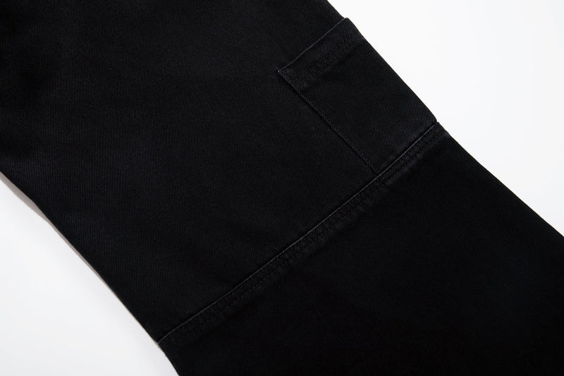 Close-up of black wide-leg jeans leg with seam detail and smooth denim texture