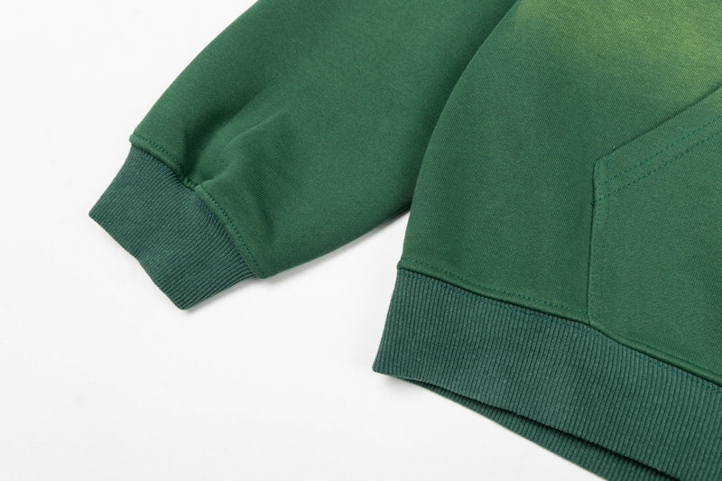 Close-up of green hoodie sleeve cuff and hem ribbing