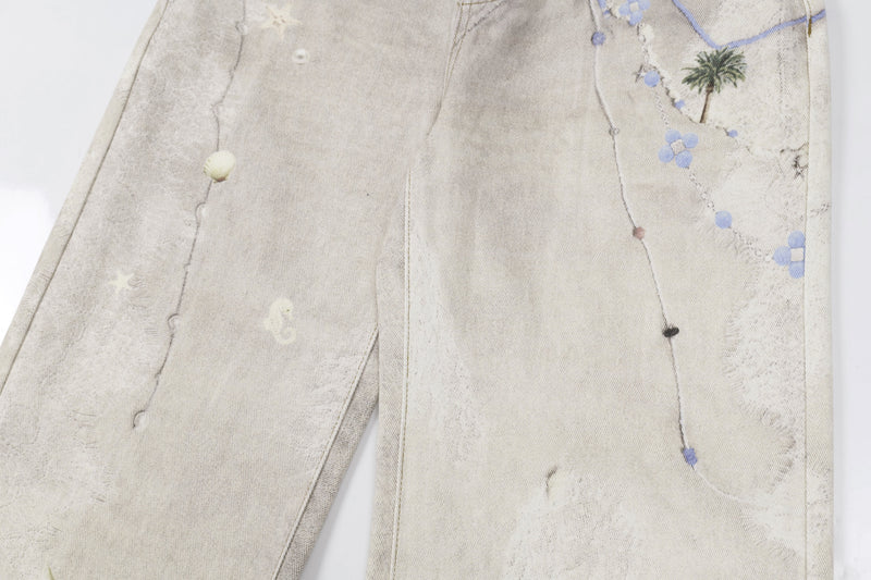 Close-up of front leg on washed botanical print jeans with palm tree and blue floral print