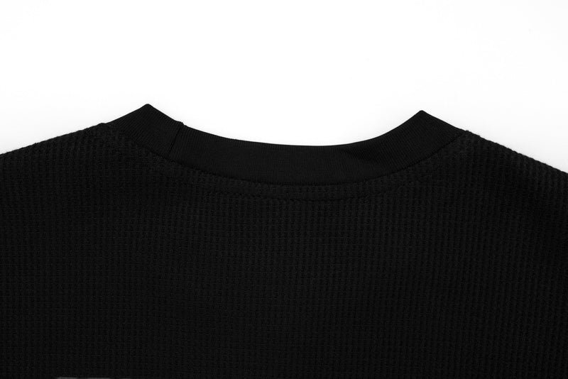 Close-up of black ribbed crew neckline on layered long sleeve tee