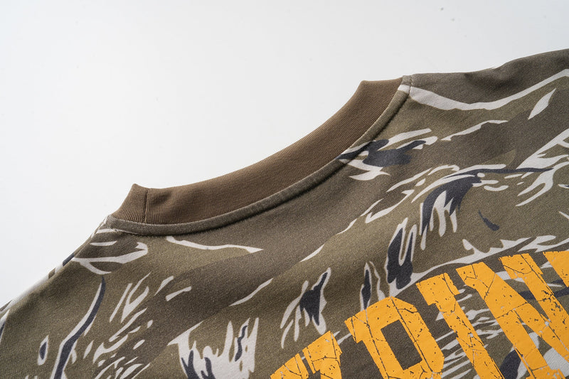 Close-up of shoulder and neckline on olive camo graphic tee with layered gray sleeve