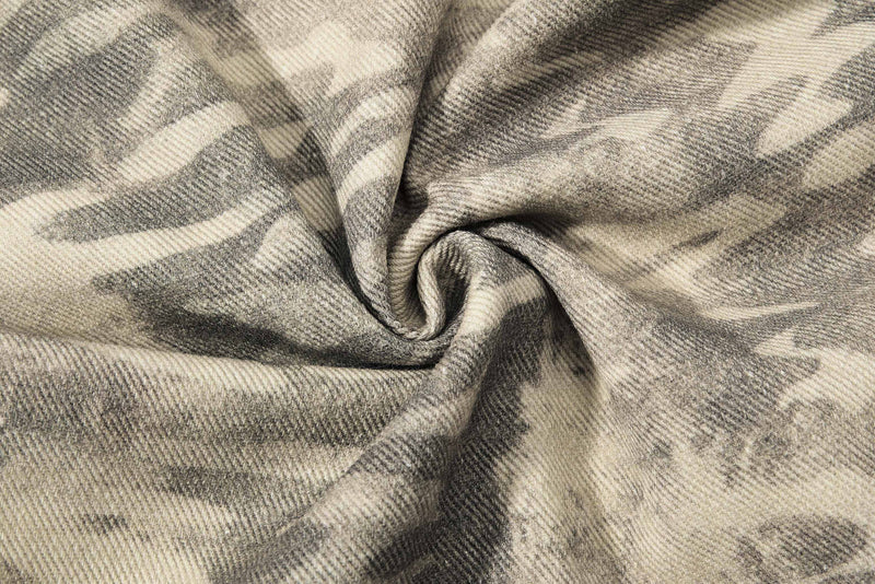 Close-up of beige and gray camouflage denim fabric with a soft, worn texture