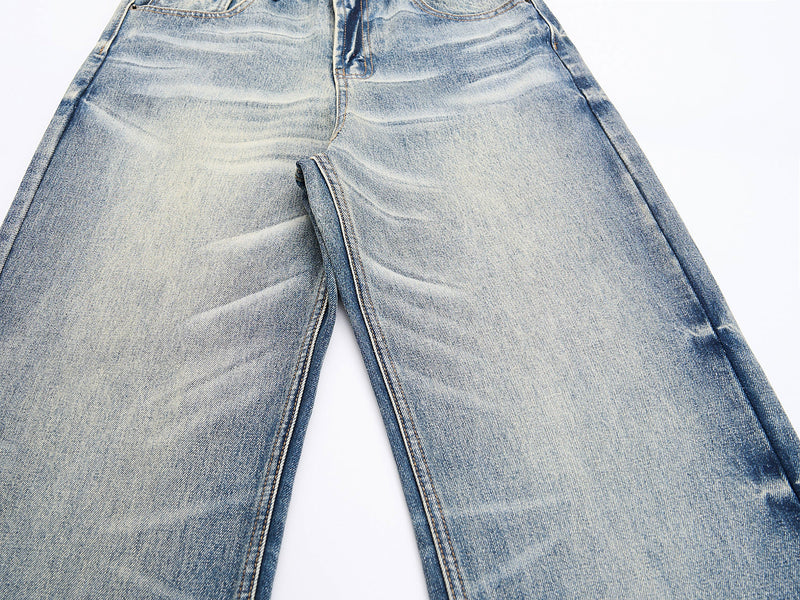 Close-up of front legs showing wide-leg cut and faded wash on blue jeans