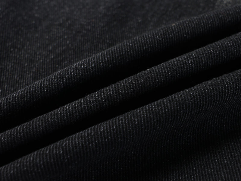 Close-up of black denim fabric texture and diagonal fold lines