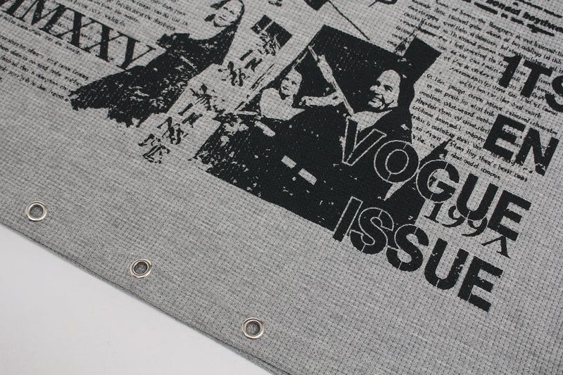 Gray waffle-knit graphic tee with black collage print and metal snap buttons at the hem