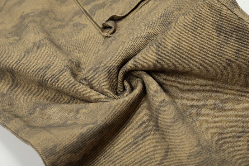 Close-up of gathered denim fabric texture on desert camo jeans