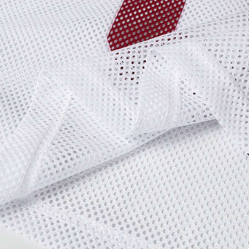 Close-up of white breathable mesh fabric with red varsity jersey detail visible underneath