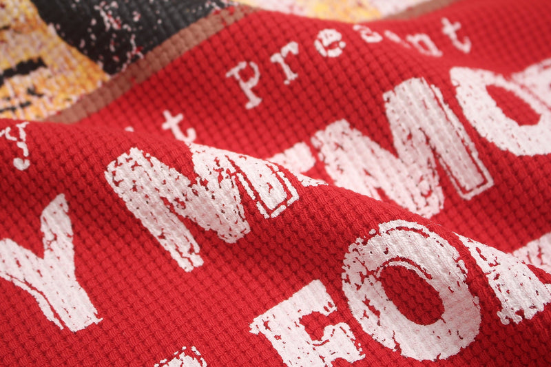 Close-up of a red oversized graphic tee with distressed white lettering and textured punk streetwear print