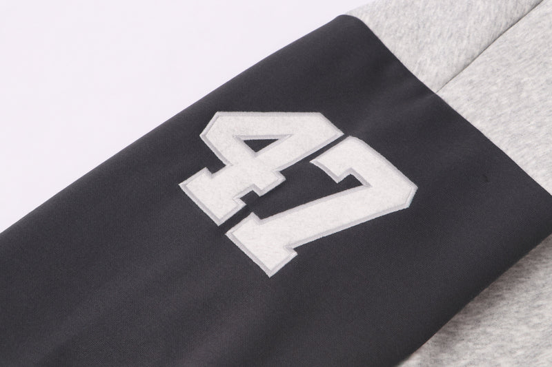 Close-up of black sleeve with large white 47 patch on varsity hoodie