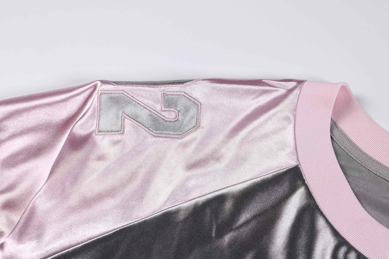 Metallic pink oversized varsity jersey tee with silver number patch and ribbed collar