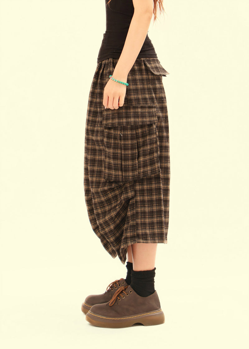 Side view of plaid cargo shorts on model with knee-length hem and cargo pocket