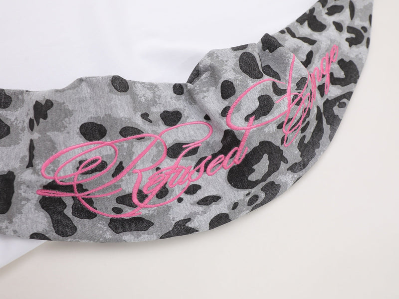 Close-up of pink script embroidery across gray leopard-print sleeve