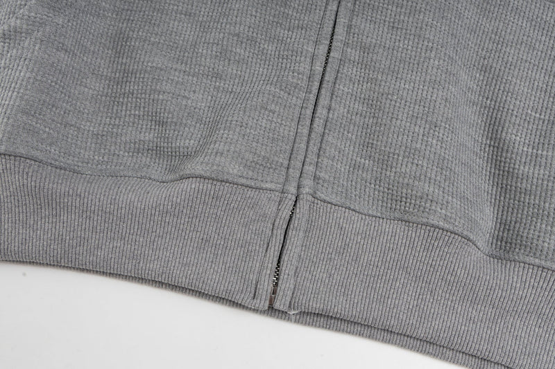 Close-up of gray hoodie ribbed hem and zipper bottom