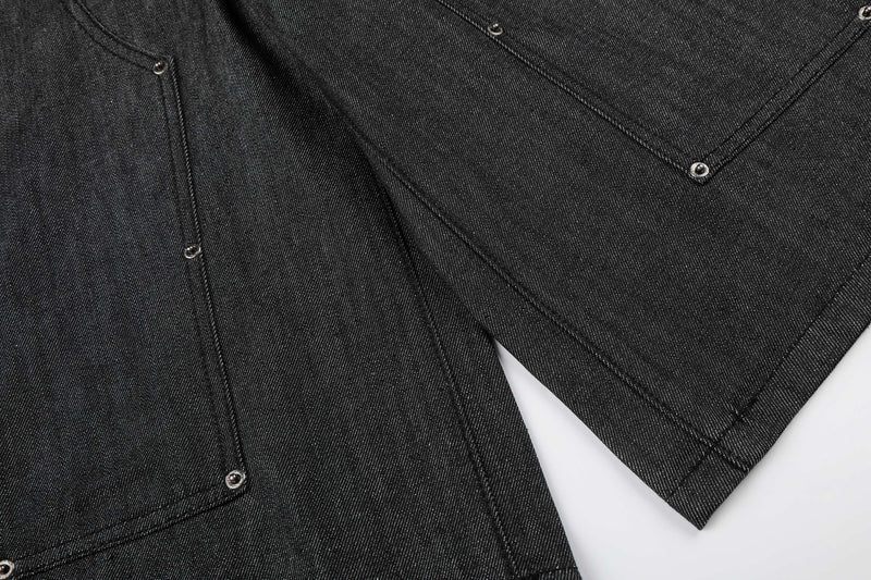 Close-up of front and side hems on black denim shorts with visible seam stitching