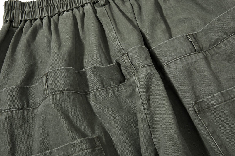 Close-up of olive green cargo pockets and pleated front panel
