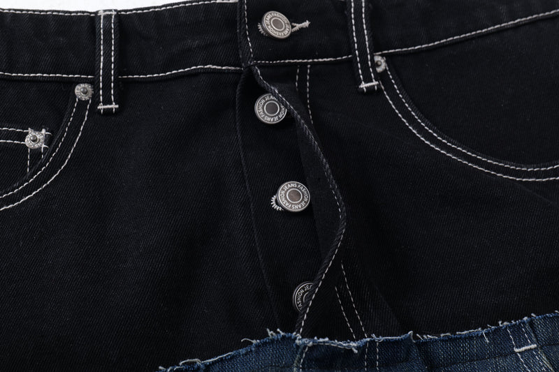 Close-up of black denim waistband with contrast stitching, button fly, and front pockets