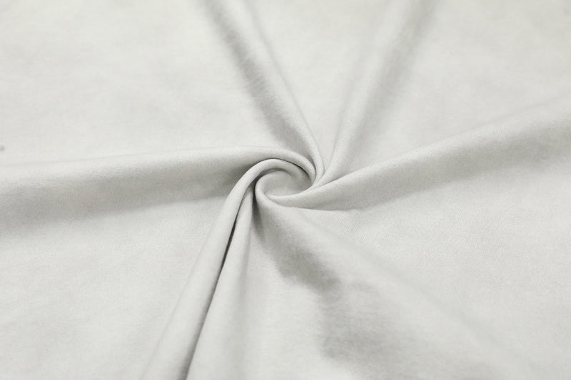 Close-up of white oversized T-shirt fabric with soft twisted folds and smooth cotton texture