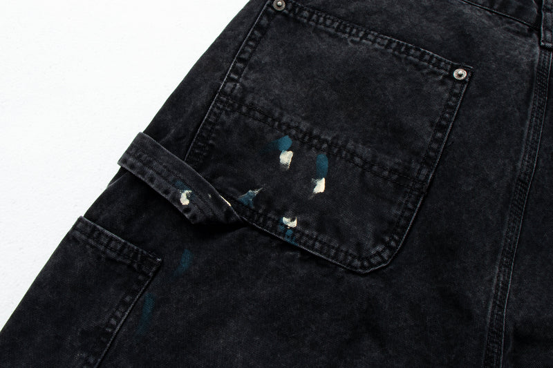 Close-up of black cargo pocket with flap and paint splatter detail