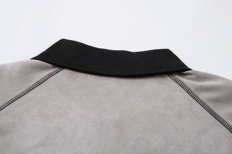 Close-up of black collar and shoulder seams on the light gray long-sleeve polo shirt