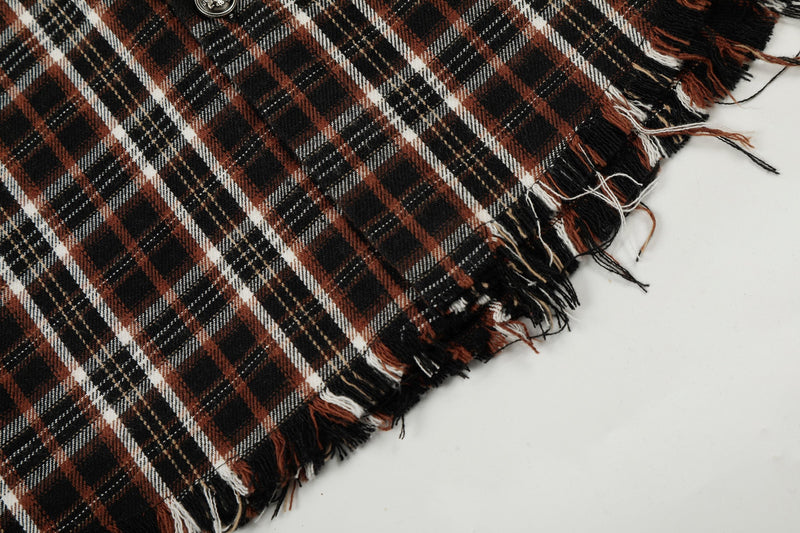Close-up of distressed black and rust plaid fabric with frayed raw edges and a streetwear look
