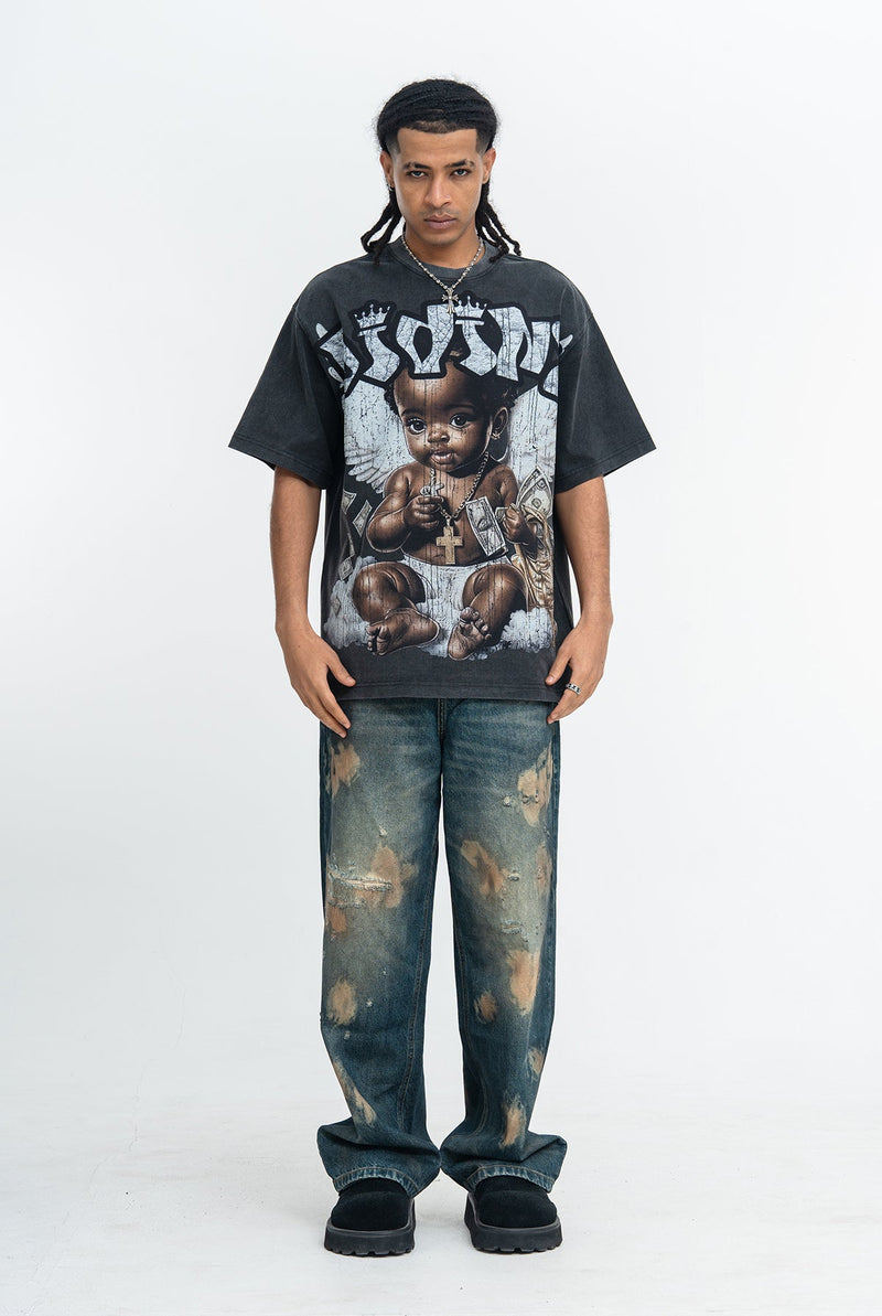 Black oversized graphic T-shirt with angel baby print, worn with distressed vintage-wash jeans and black sneakers
