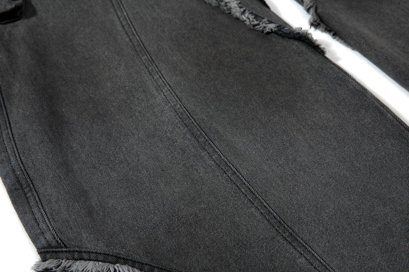 Close-up of smooth black denim leg panel with diagonal seam stitching