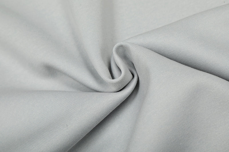 Close-up of light gray fabric folded to show smooth knit texture