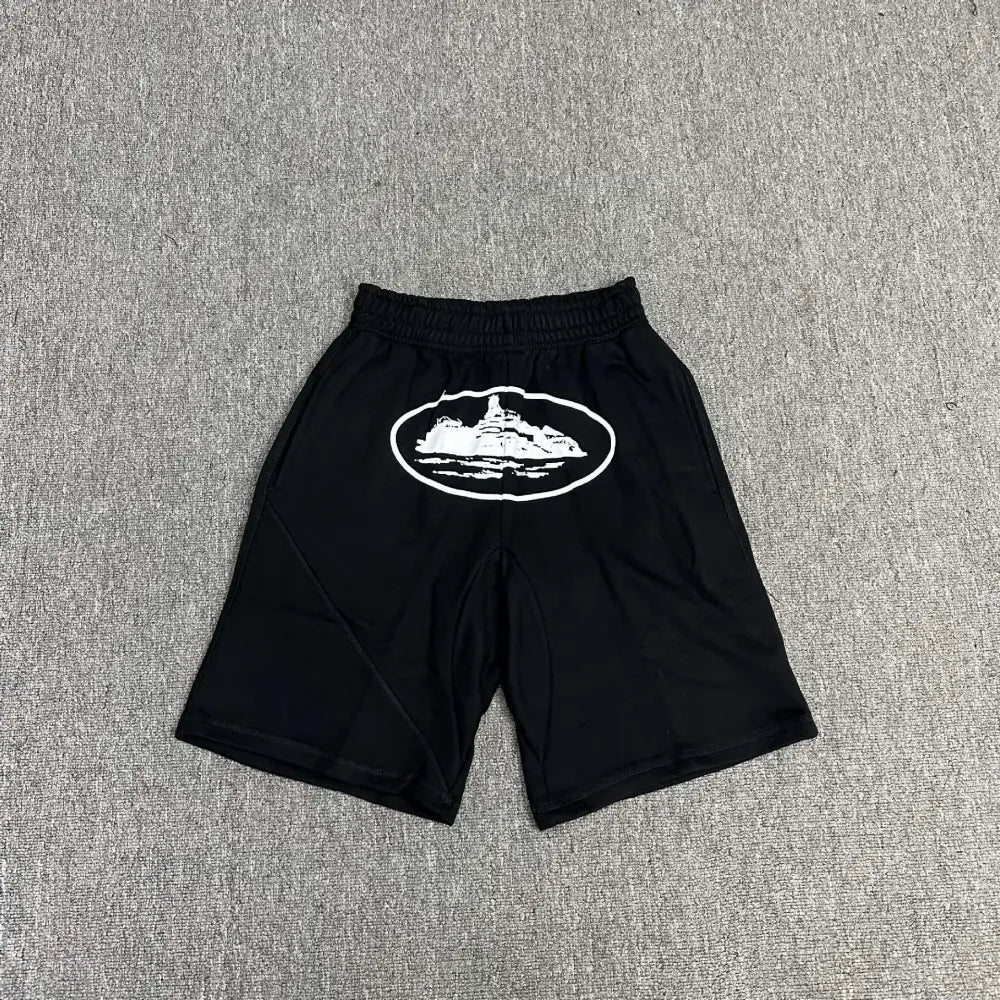 Black Corteiz jogger shorts laid flat, showing a large white oval graphic print on the front panel